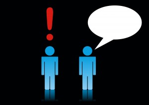 Two stick men, one with Exclamation mark over head the other with speech bubble