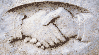 Image of two hands shaking carved in stone
